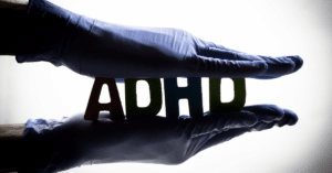Holding an ADHD sign between two hands. Showing how to deal with and treat ADHD